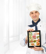 Photo: cook man showing a digital tablet with menu cook man showing a digital tablet with menu