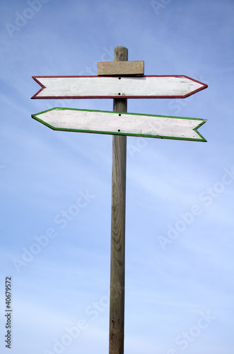 Photo: Double directional signs isolated on blue sky Double directional signs isolated on blue sky