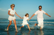 Happy summer vacation - family playing at the beach