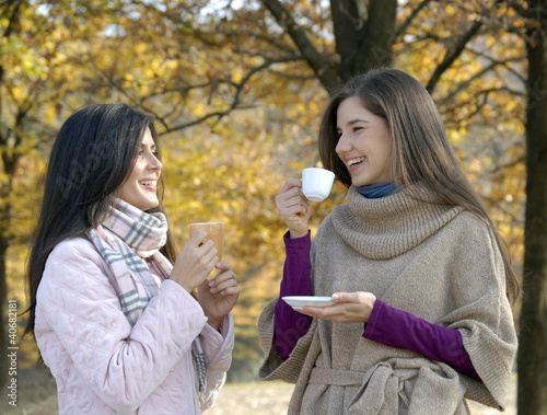 Photo: Amigas disfrutando de un café en otoño. Amigas disfrutando de un café en otoño.