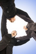 Detaily fotografie A group handshake between three young business persons