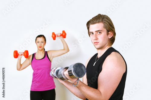 Photo: Exercising couple with focus on man Exercising couple with focus on man