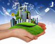 Human hand holding a green landscape