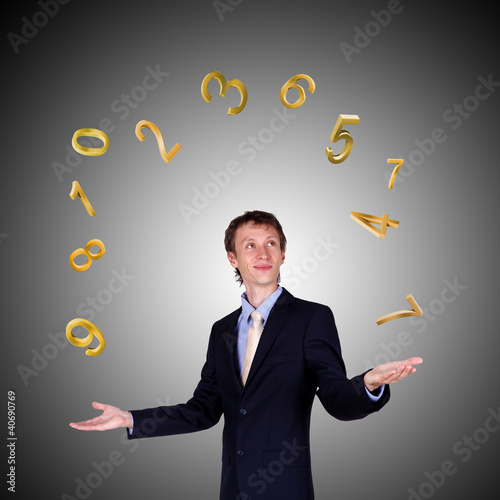 Photo: Business man juggling with numbers and symbols Business man juggling with numbers and symbols