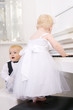 boy and girl playing on a white piano boy and girl playing on a white piano