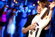 Young guitar player performing in night club