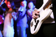 Young guitar player performing in night club