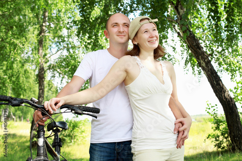 Photo: Young couple on the bikes in the park Young couple on the bikes in the park