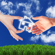 House and human hand against blue sky House and human hand against blue sky