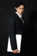 Handsome young business man holding a laptop looking away
