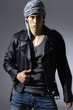 handsome young elegant man standing on gray background