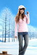 Beautiful winter girl in a hat posing in winter park
