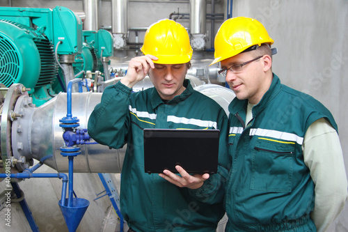Photo: Industrial workers with notebook, teamwork Industrial workers with notebook, teamwork