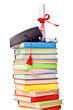 Cap and diploma on top of stack of books Cap and diploma on top of stack of books