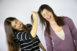 Girl pulling hard long hair of her friend