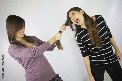 Photo: Girl pulling the hair to another girl that shouts Girl pulling the hair to another girl that shouts