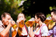 Zwei glückliche Paare sitzen im Biergarten