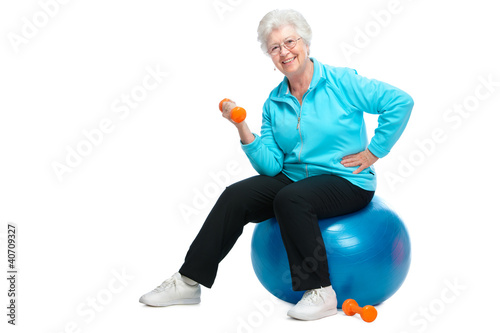 Photo: Senior woman working with weights in gym Senior woman working with weights in gym