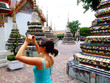 Woman taking a photo in Wat Pho, Bangkok, Thailand. Woman taking a photo in Wat Pho, Bangkok, Thailand.