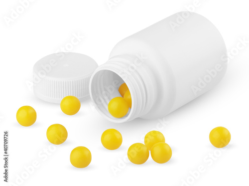 Photo: Open plastic bottle with yellow vitamins isolated on white Open plastic bottle with yellow vitamins isolated on white
