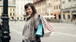 Happy woman with shopping bags in the city, steadicam shot