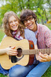 Teens having fun with guitar in park