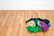 Pile of colorful clothes on the wooden floor Pile of colorful clothes on the wooden floor