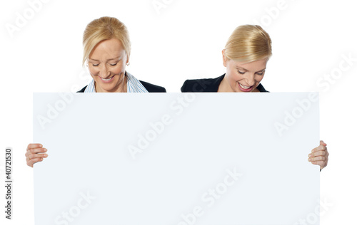 Photo: Female business executives looking at blank banner ad Female business executives looking at blank banner ad