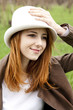 Young fashion girl in whte hat at green spring grass.