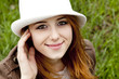 Young fashion girl in whte hat at green spring grass.