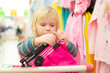Adorable baby on cart choose clothes in supermarket