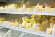 Variety of cheeses  pieces on shelves in supermarket
