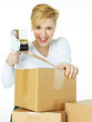 Foto: Pretty woman at work wraps up a packet for delivery Pretty woman at work wraps up a packet for delivery