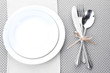 White empty plates with fork, spoon and knife tied with a ribbon