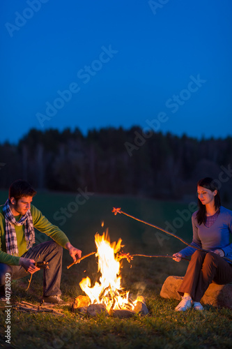 Photo: Couple cook by bonfire romantic night countryside Couple cook by bonfire romantic night countryside
