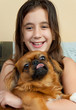 Hispanic girl carrying her small pekingese dog