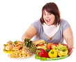 Woman choosing between fruit and hamburger.