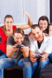 Freunde sitzen an der Spielkonsole zusammen