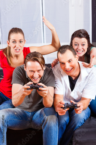 Photo: Freunde sitzen an der Spielkonsole zusammen Freunde sitzen an der Spielkonsole zusammen