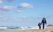 Dad with a small child walking on a winter beach.