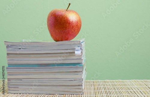 Photo: stack of magazines and red apple stack of magazines and red apple