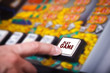 Man's hand pressing play button on a slot machine