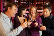 Photo: Group Of Friends Enjoying Drink Together In Bar Group Of Friends Enjoying Drink Together In Bar