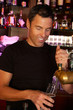 Foto: Portrait Of Barman Standing Behind Bar Pouring Beer Portrait Of Barman Standing Behind Bar Pouring Beer