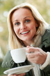 Woman In Outdoor CafŽ With Hot Drink  Wearing Winter Clothes
