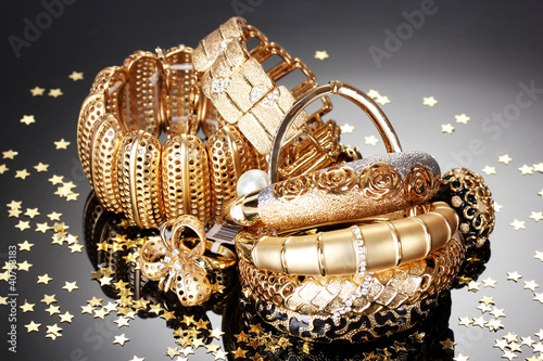 Photo: Beautiful golden jewelry on grey background Beautiful golden jewelry on grey background