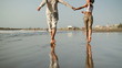 Young couple running on the beach, slow motion