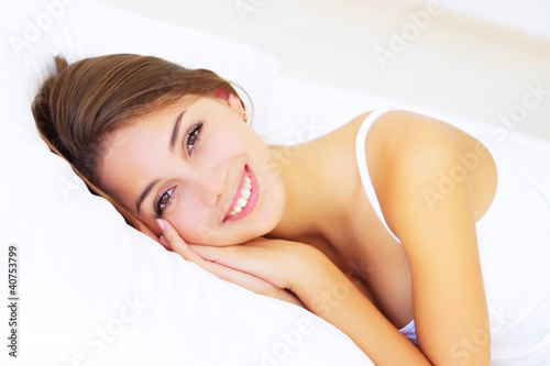 Foto: smiling girl lying on the bed smiling girl lying on the bed