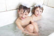 two smiling children having bath