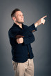 Happy casual man finger pointing over grey background. Happy casual man finger pointing over grey background.